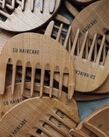 Kaemme aus Kirschholz liegen uebereinander.