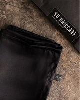 Detailansicht der glatten Seidenstruktur des SU SILK PILLOW – schützt Haut und Haar vor Reibung.