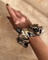 Detailansicht der glatten Seidenstruktur des SU SILK SCRUNCHIE BIG – schützt das Haar und verleiht Glanz.