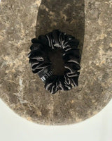 SU SILK SCRUNCHIE SMALL in Schwarz – luxuriöses Haargummi aus 100 % upgecycelter Maulbeerseide für empfindliches Haar.
